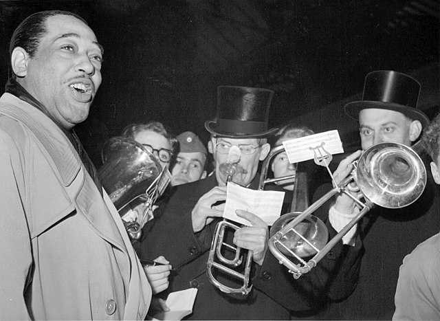 1950 photograph of Duke Ellington and his band in Copenhagen by Aage Sørensen. Ellington served as the subject of four episodes of the series *[Evolution of Jazz](/programs/evolution-of-jazz/)*. Public domain photograph retrieved from [Wikimedia](https://commons.wikimedia.org/wiki/File:Duke-Ellington-arrives-in-Copenhagen-with-his-band-352130627073.jpg).